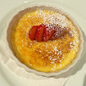 Classic creme brulee with caramelized sugar and strawberry